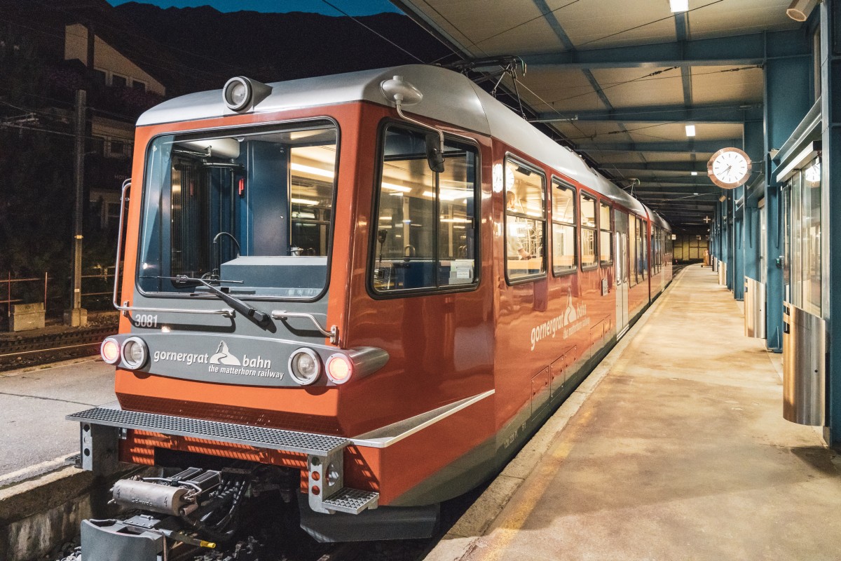 Erster Zug der Gornergratbahn in Zermatt am frühen Morgen