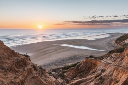 Sonnenuntergang am Baylys Beach in Neuseeland